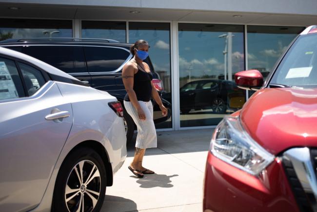 © Bloomberg. A customer wearing a protective mask looks at different cars displayed outside for sale at a Honda Motor Co. dealership in Southfield, Michigan, U.S., on Tuesday, May 26, 2020. The coronavirus pandemic ripped through the economy with frightening speed, spurring job losses in every U.S. state in April. The largest deterioration in the labor market occurred in Michigan, Vermont and New York.