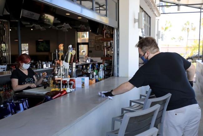 © Bloomberg. JACKSONVILLE BEACH, FLORIDA - MAY 04: Employees of Cruisers Grill prepare for customers as the state of Florida enters phase one of the plan to reopen the state on May 04, 2020 in Jacksonville Beach, Florida. Restaurants, retailers, beaches and some state parks reopen today with caveats, as the state continues to ease restrictions put in place to contain the coronavirus (COVID-19). (Photo by Sam Greenwood/Getty Images)