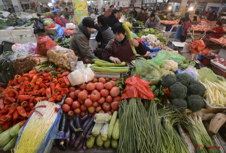 © Reuters/Stringer. A vendor (C) weighs vegetable at a market in Fuyang, Anhui province, Dec. 10, 2014.