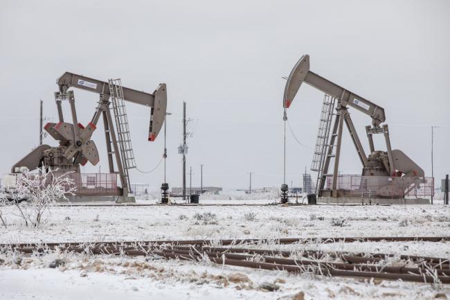 © Bloomberg. Pumpjacks operate in the snow in the Permian Basin in Midland, Texas, U.S. Photographer: Matthew Busch/Bloomberg