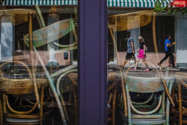 © Bloomberg. Pedestrians are reflected in the windows of a closed restaurant in the South Beach neighborhood of Miami Beach, Florida, U.S., on Friday, March 20, 2020. Mayor Carlos Gimenez announced Wednesday that all public beaches, non-essential retail, private educational facilities, casinos and entertainment activities in Miami-Dade County will close as of Thursday night. Photographer: Scott McIntyre/Bloomberg