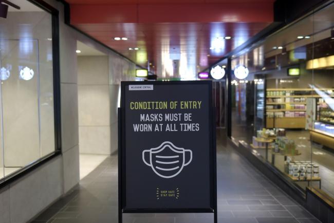 © Bloomberg. An information sign informs all customers that they must wear a protective mask at all times at a shopping precinct in Melbourne, Australia, earlier in July.