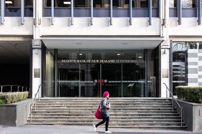 © Bloomberg. A pedestrian walks past the Reserve Bank of New Zealand (RBNZ) building in Wellington, New Zealand, on Saturday, June 22, 2019. The out-of-favor kiwi dollar has tumbled about 3% this quarter as the Reserve Bank of New Zealand turned dovish and cut interest rates, the first central bank in the developed world to do so. Economic growth held at a five-year low in the three-months through March, leaving the door open for further easing. Photographer: Birgit Krippner/Bloomberg