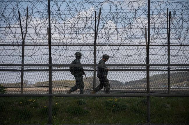 © Bloomberg. South Korean soldiers patrol along a barbed wire fence Demilitarized Zone (DMZ) separating North and South Korea, on the South Korean island of Ganghwa on April 23, 2020.  Photographer: Ed Jones/AFP via Getty Images