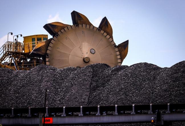© Bloomberg. A bucket-wheel reclaimer stands next to a pile of coal at the Port of Newcastle in Newcastle, New South Wales, Australia, on Monday, Oct. 12, 2020. Prime Minister Scott Morrison warned last month that if power generators don't commit to building 1,000 megawatts of gas-fired generation capacity by April to replace a coal plant set to close in 2023, the pro fossil-fuel government would do so itself. Photographer: David Gray/Bloomberg