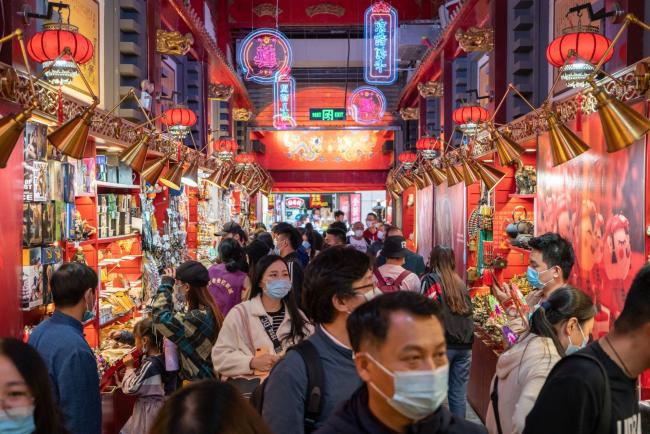 © Bloomberg. Shoppers look at offerings from souvenir shops in Beijing, Oct. 4.