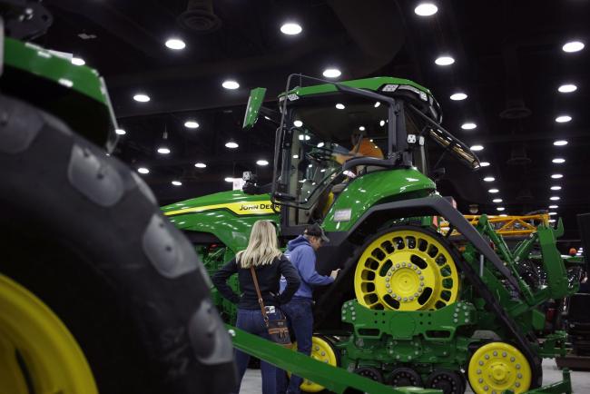 © Bloomberg. Attendees examine a Deere Co. John Deere tractor at the National Farm Machinery Show in Louisville, Kentucky, U.S. on Friday, Feb. 14, 2020. The show offers a selection of cutting-edge agricultural products, equipment and services available in the farming industry. Photographer: Luke Sharrett/Bloomberg