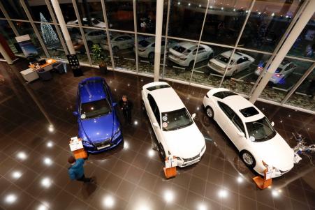 © Reuters. A customer looks at cars in a Lexus showroom in the Siberian city of Krasnoyarsk. Several car dealerships were reported to have suspended sales, unsure how far the rouble would fall.