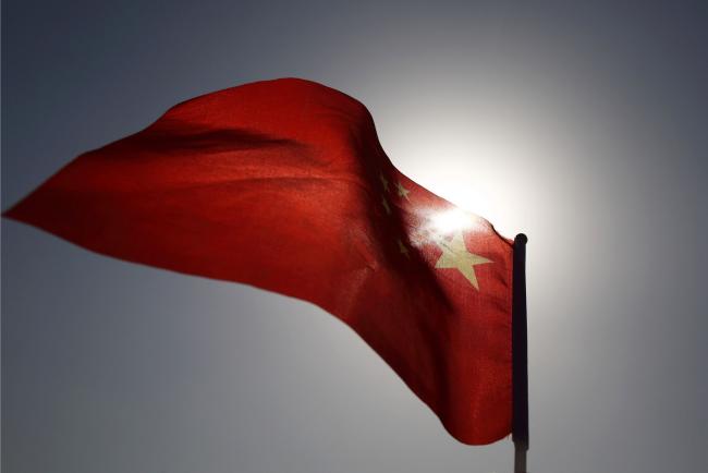 © Bloomberg. A Chinese national flag flies in Beijing, China, on Monday, March 2, 2015. China's annual meeting of the National People's Congress, which begins March 5 in Beijing, is expected to set government policies for the year on issues ranging from economic growth to military spending and pollution. Photographer: Tomohiro Ohsumi
