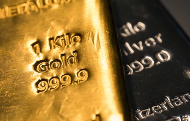 © Bloomberg. A one-kilogram gold bar sits on top of a one-kilogram silver bar at Gold Investments Ltd. bullion dealers in this arranged photograph in London, U.K., on Wednesday, July 29, 2020. Gold held its ground after a record-setting rally as investors awaited the outcome of a Federal Reserve meeting amid expectations policy makers will remain dovish, potentially spurring more gains. Photographer: Chris Ratcliffe/Bloomberg