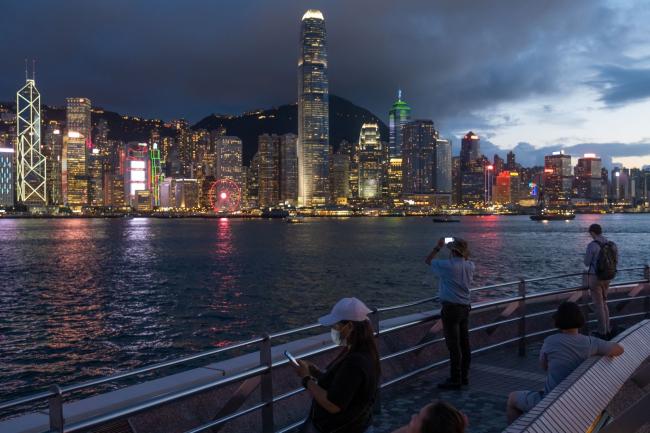 © Bloomberg. People use their smartphones along the Victoria Harbour waterfront in Tsim Sha Tsui district in Hong Kong, China, on Tuesday, July 7, 2020. Internet giants from Facebook Inc. to Google and Twitter Inc. say they won’t process user data requests from the Hong Kong government amid concerns that a new security law could criminalize protests.