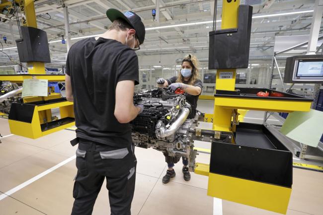 © Bloomberg. Employees wear protective face masks as they assemble Mercedes-Benz AG S-Class automobile M256 six cylinder motors in the automaker's powertrain factory, operated by Daimler AG, as it reopens for business in Stuttgart, Germany, on Wednesday, April 22, 2020. The financial fallout from forced factory shutdowns aimed at minimizing contagion risks is set to trigger the deepest economic crisis since World War II. Photographer: Alex Kraus/Bloomberg