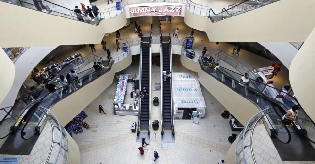 © Bloomberg. Shoppers walk through the Queens Center shopping mall in the Queens borough of New York, U.S., on Wednesday, Sept. 9, 2020. New York City malls have the green light to reopen Wednesday under the condition that they have enhanced air filtration systems in place.