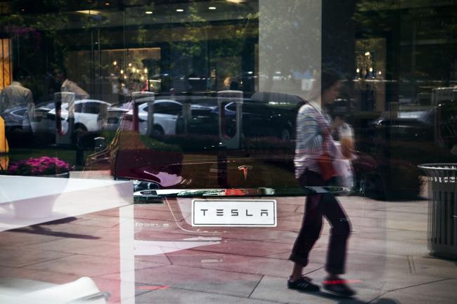 © Bloomberg. The Tesla Inc. logo is displayed on a Model S electric vehicle sitting in the window of one of the company's showrooms in Beijing, China, on Friday, May 10, 2019. Beijing has vowed to retaliate after U.S. President Donald Trump followed through with his threat to raise tariffs Friday on $200 billion of Chinese imports to 25% from 10% percent. Photographer: Giulia Marchi/Bloomberg
