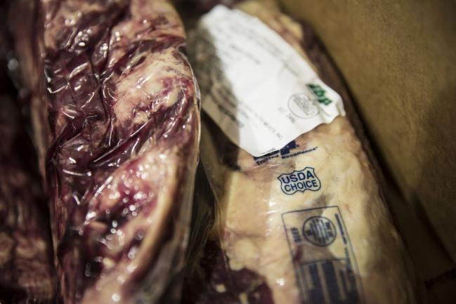 © Bloomberg. Cuts of imported Tyson Fresh Meats Inc. beef sit inside a box at the Suzhou Huadong Foods Ltd. cold storage facility in Suzhou, China, on Saturday, July 7, 2018. China's retaliatory tariffs on U.S. goods struck just as one of its biggest meat importers was rushing a shipment from California through Shanghai customs. Now Suzhou Huadong is saddled with a stack of unaffordable American steak. Photographer: Qilai Shen/Bloomberg