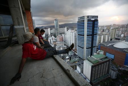 © Reuters/Jorge Silva. Men rest after salvaging metal on the 30th floor of the Tower of David skyscraper in Caracas, Venezuela, Feb. 3, 2014. The 45-story skyscraper was abandoned around 1994 after the death of its developer and the collapse of the financial sector. Now about 3,000 people call the tower their home.