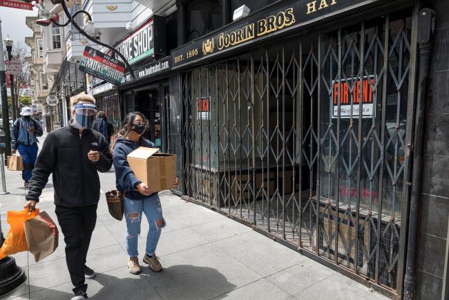 © Bloomberg. People wearing protective masks and face shields walk past a store front for rent in San Francisco, California, U.S., on Wednesday, Aug. 5, 2020. California's second round of coronavirus-related shutdowns, among the nation's strictest measures, are already causing pain for the most populous state's labor market and portend a deterioration in the overall U.S. employment picture for July.