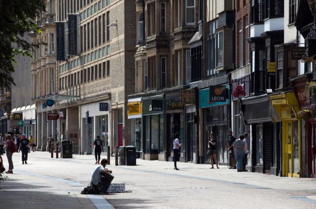 © Bloomberg. A busker plays a guitar on a pedestrianised shopping precinct in Oxford, U.K., on Wednesday, May 27, 2020. The U.K. government's plans to allow most stores to reopen can't come soon enough for retailers, with new figures showing the ongoing damage from the lockdown.