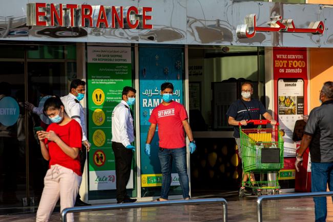 © Bloomberg. Security guards guide shoppers at the entrance of a market in Dubai, on April 23. Photographer: Christopher Pike/Bloomberg