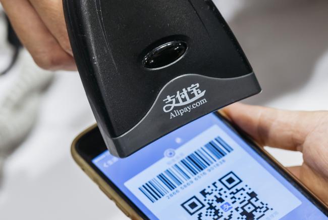 © Bloomberg. An employee scans a quick response (QR) code displayed on the Ant Financial Services Group's Alipay app, an affiliate of Alibaba Group Holding Ltd., inside a Sa Sa International Holdings Ltd. store in an arranged photograph in Hong Kong, China, on Tuesday, Nov. 1, 2016. The urgency to prepare regulatory environments for fintech is growing as banks begin offering digital services such as biometric authentication and as mobile-payment systems such as Apple Pay and AliPay are introduced around the region. Photographer: Anthony Kwan/Bloomberg