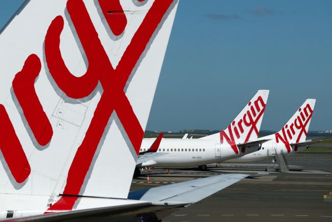 © Bloomberg. Grounded aircraft operated by Virgin Australia Holdings Ltd. stand on the tarmac at Sydney Airport in Sydney, Australia, on Tuesday, April 21, 2020. Virgin Australia became Asia's first airline to fall to the coronavirus after the outbreak deprived the debt-burdened company of almost all income. Photographer Brendon Thorne/Bloomberg Photographer: Brendon Thorne/Bloomberg