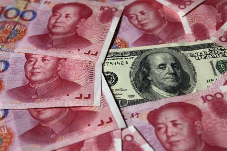 © Reuters/Petar Kujundzic. On Tuesday, China slashed the reference rate on the yuan by a record 1.9 percent, as the country copes with falling exports, a volatile stock market and a slowing economy. Pictured: A U.S. 0 banknote is placed next to 100 yuan banknotes in this picture illustration taken in Beijing on Oct. 16, 2010.