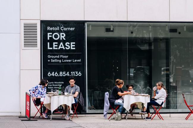 © Bloomberg. Diners eat outside a French restaurant in front of a storefront for lease.  Photographer: Nina Westervelt/Bloomberg