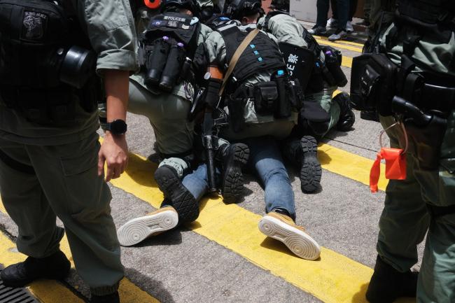 © Bloomberg. Police make an arrest during a protest in Hong Kong on July 1. Photographer: Roy Liu/Bloomberg