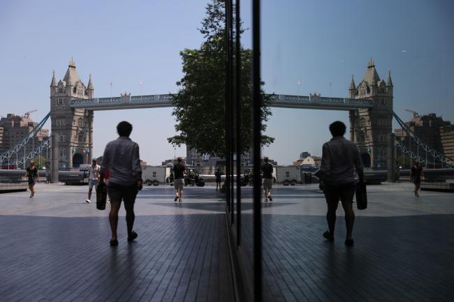 © Bloomberg. Pedestrians walk towards Tower Bridge in London, U.K., on Wednesday, June 24, 2020. Getting people back into stores after a 12-week pause is crucial for Britain's 400 billion-pound ($502 billion) retail industry, and for the country at large, which relies on consumer spending for about 60% of gross domestic product. Photographer: Simon Dawson/Bloomberg