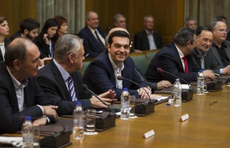 © Reuters/Marko Djurica. Greek Prime Minister Alexis Tsipras (3rd L) smiles during the first meeting of new cabinet post elections in the parliament building in Athens January 28, 2015.