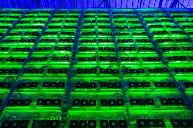 © Bloomberg. Illuminated mining rigs operate inside racks at the CryptoUniverse cryptocurrency mining farm in Nadvoitsy, Russia, on Thursday, March 18, 2021. The rise of Bitcoin and other cryptocurrencies has prompted the greatest push yet among central banks to develop their own digital currencies. Photographer: Andrey Rudakov/Bloomberg