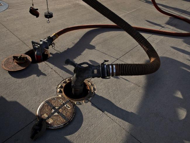 © Bloomberg. Fuel lines sit connected to underground storage tanks as fuel is delivered at a Phillips 66 gas station in Princeton, Illinois, U.S., on Wednesday, April 1, 2020. Even with the combination of some Canadian pullback, stripper wells going offline and announced shale cuts, that may not be enough to stop oil prices from going lower as demand craters and supply from OPEC means major increases in stockpiles in the second quarter. Photographer: Bloomberg/Bloomberg