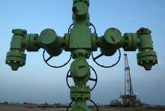 © Bloomberg. ON NORTHERN BORDER BETWEEN IRAQ AND KUWAIT, KUWAIT - JANUARY 22: A wellhead is shown in front of a Kuwait Oil Company drilling rig January 22, 2003 on the northern border between Iraq and Kuwait in Kuwait. Kuwait produces approximately ten percent of the worlds oil and the country has promised to increase production, as needed, in the event of a war in Iraq. (Photo by Joe Raedle/Getty Images)