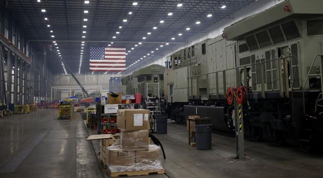 © Bloomberg. An American flag hangs above an assembly line in Fort Worth, Texas. Photographer: Luke Sharrett/Bloomberg