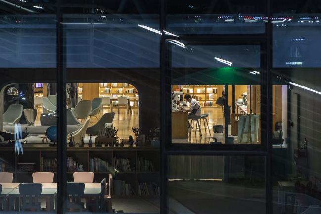 © Bloomberg. An employee is seen through a window as he sits in a store at night in downtown Guangzhou, China, on Tuesday, May 12, 2020. The Pearl River Delta industrial belt has served as one of China’s most important growth engines since the Communist Party opened the economy four decades ago, propelling its rise to become one of the world’s leading powers. But now in Guangdong the situation is getting dire in some labor-intensive sectors where the widespread struggle to earn cash risks turning into a big political problem for Chinese President Xi Jinping. Photographer: Qilai Shen/Bloomberg