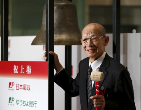 © Reuters. Japan Post Holdings Co. President Taizo Nishimuro poses before ringing a bell during a ceremony to mark the company's debut on the Tokyo Stock Exchange in Tokyo, No. 4, 2015. Shares of Japan Post Holdings Co. and Japan Post Bank Co. soared Wednesday after the country's biggest privatization since the 1980s raised 1.4 trillion yen (.6 billion) for the government.