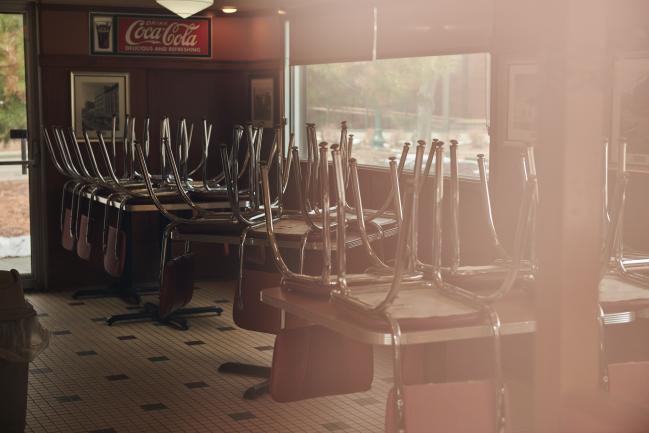 © Bloomberg. Chairs are stored on top of tables at a closed diner. Photographer: Dan Brouillette/Bloomberg