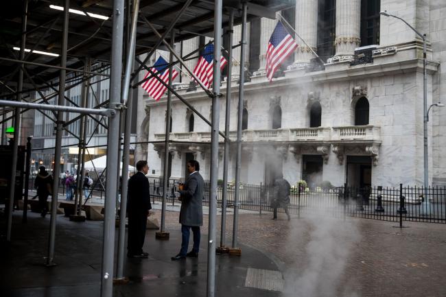 © Bloomberg. Pedestrians pass in front of the New York Stock Exchange (NYSE) in New York, U.S., on Wednesday, Feb. 26, 2020. U.S. equities swung between gains and losses as investors digested fresh evidence of the widening coronavirus outbreak. Photographer: Michael Nagle/Bloomberg