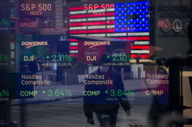 © Bloomberg. Monitors displaying stock market information are seen through the window of the Nasdaq MarketSite. Photographer: Michael Nagle/Bloomberg