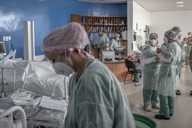 © Bloomberg. Healthcare workers treat patients inside a Covid-19 intensive care unit (ICU) at a field hospital in the Heliopolis favela of Sao Paulo.