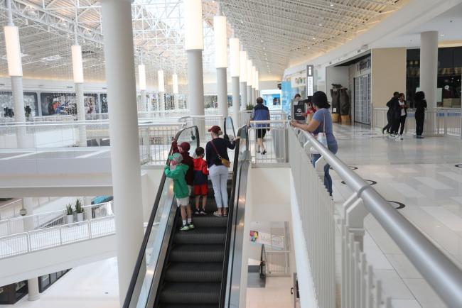 © Bloomberg. Shoppers ride an escalator at a mall in Bloomington, Minnesota in June 10.