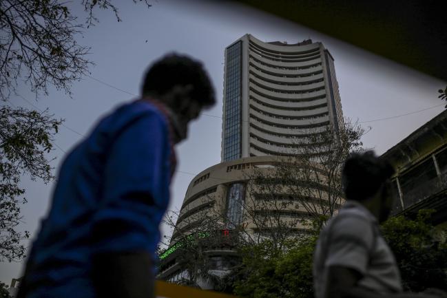 © Bloomberg. Pedestrians walk The Bombay Stock Exchange (BSE) building in Mumbai, India, on Saturday, March 21, 2020. Authorities ordered all non-essential businesses in Mumbai and across the broader state to shut from midnight through the end of March to contain the spread of the novel coronavirus. Photographer: Dhiraj Singh/Bloomberg