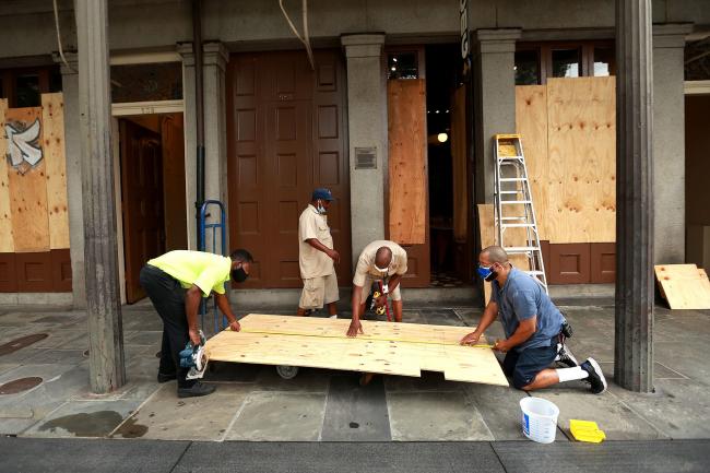 © Bloomberg. Workers board up windows in the French Quarter in anticipation of Hurricane Marco and Tropical storm Laura on August 23, 2020 in New Orleans, Louisiana. Photographer: Sean Gardner/Getty Images