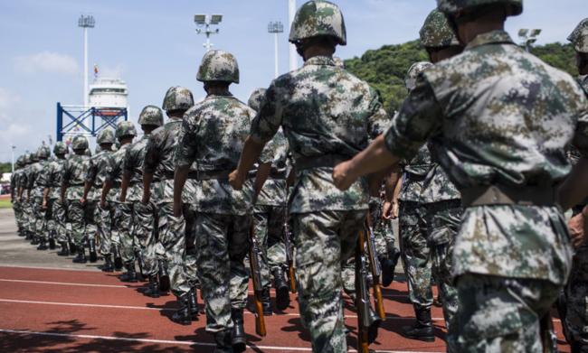 © Bloomberg. Members of the People's Liberation Army march during a demonstration at an open day at the Ngong Suen Chau Barracks in Hong Kong in 2015.