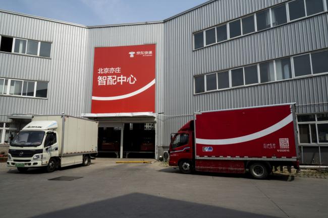 © Bloomberg. Trucks wait to be loaded with parcels at a JD.com Inc. delivery station in Beijing, China, on Tuesday, April 14, 2020. JD, China's closest analog to Amazon.com Inc., already serves more than 360 million people -- surpassing the U.S. population. Xu Lei, chief executive officer of JD's retail division, now hopes to extend its presence on social media and investing in hot new areas like grocery delivery. Photographer: Giulia Marchi/Bloomberg