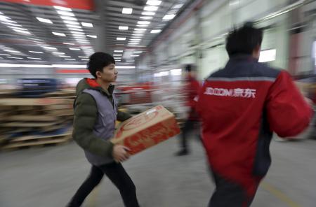 © Reuters/Jason Lee. Chinese retail sales rose above expectations in October. Pictured: Employees work at a JD.com logistic center in Langfang, Hebei province, Nov. 10, 2015.