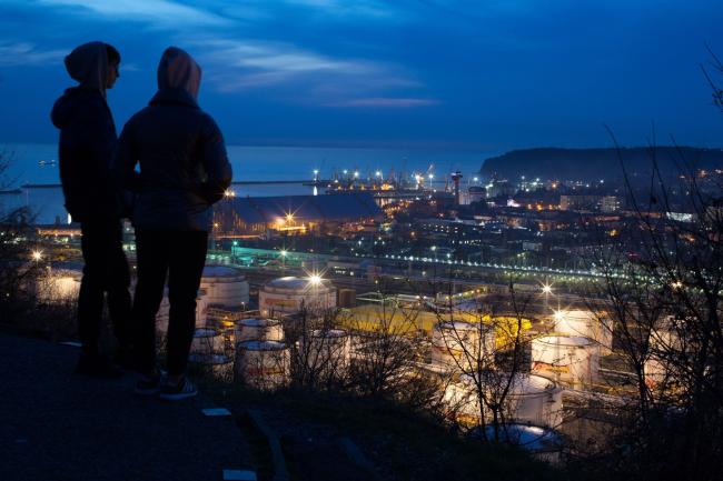 © Bloomberg. Oil storage tanks stand illuminated at night at the RN-Tuapsinsky refinery, operated by Rosneft Oil Co., in Tuapse, Russia, on Sunday, March 22, 2020. Oil resumed gains on signs that the world’s biggest producers are moving toward a deal to end their price war and cut output.