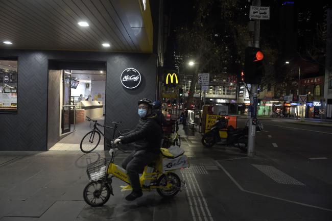 © Bloomberg. A food dellivery courier arrives to pic up an order from a McDonalds restaurant in Melbourne on July 30.