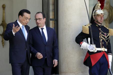 © Reuters. French President Francois Hollande (C) accompanies Chinese Premier Li Keqiang (L) as he leaves after a meeting at the Elysee Palace in Paris, France, June 30, 2015.