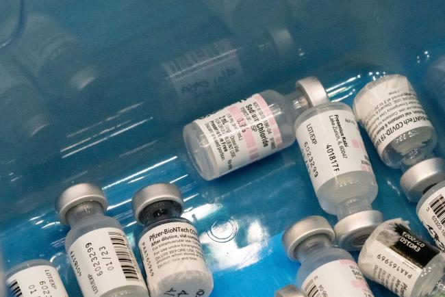 © Bloomberg. Empty vials of sodium chloride and the Pfizer-BioNTech Covid-19 vaccine at a community vaccination clinic inside the Viejas Arena on the campus of San Diego State University in San Diego, California.